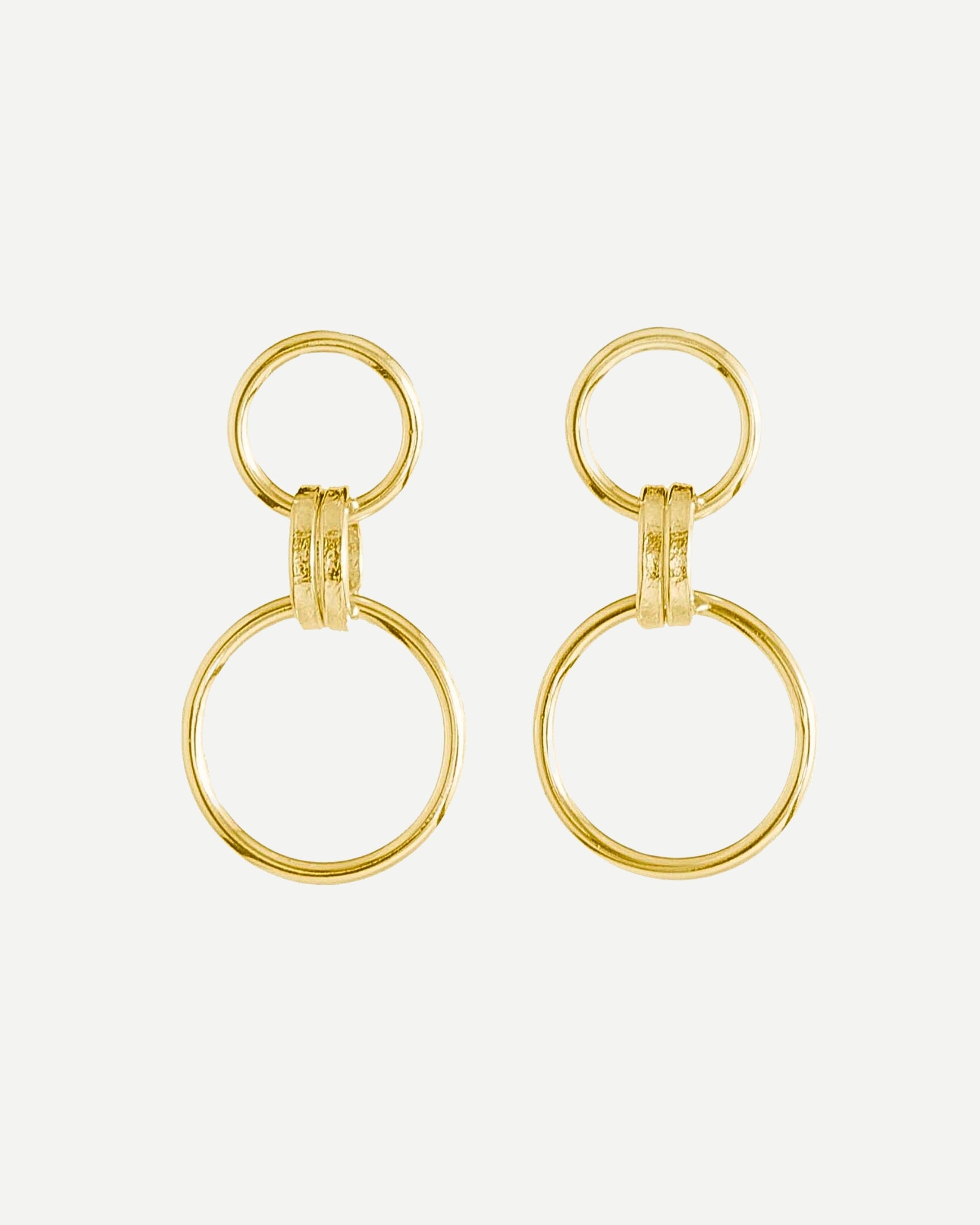 Bold gold drop earrings made from large and small textured loops on white background