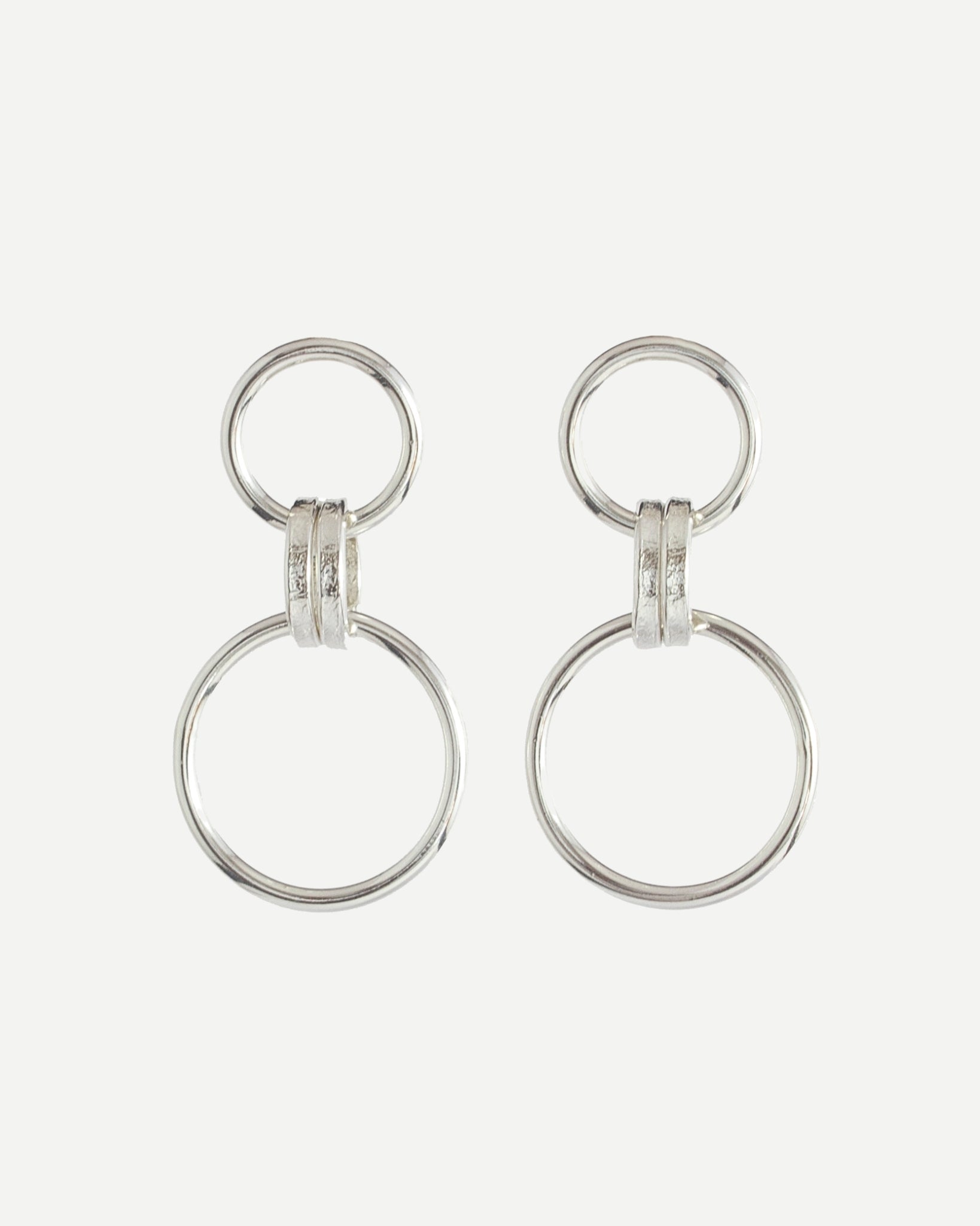 Polished sterling silver earrings with minimalist loop design on white background