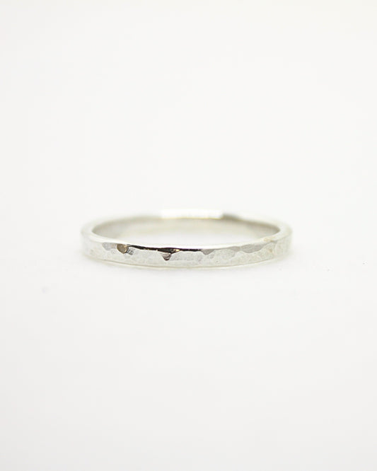 Dainty sterling silver stacking ring with reflective dimpled surface texture on white background