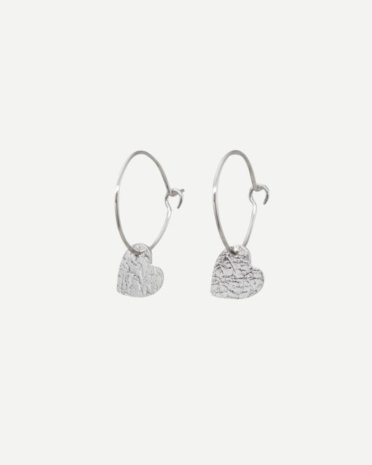 Dainty silver hearts with delicate textured surface hanging from silver hoops