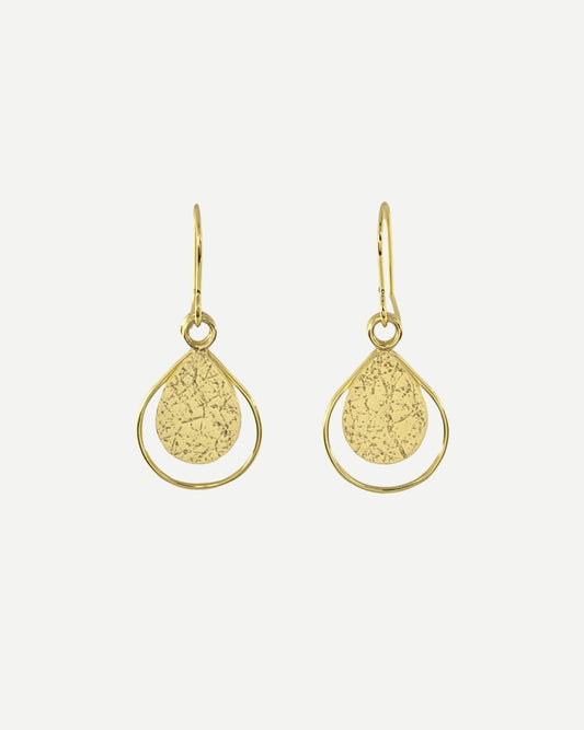 Gold earrings consisting of textured teardrops framed within thin teardrop-shaped wire and hanging from handmade gold hooks, on white background