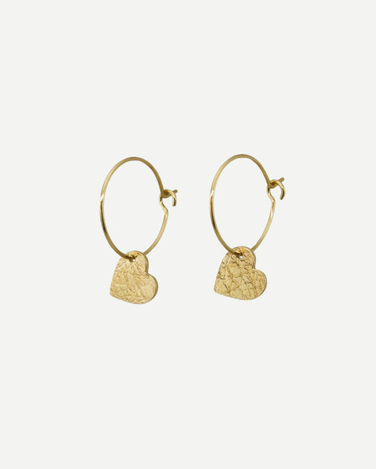 Textured gold hearts hanging from gold hoops with off-white background