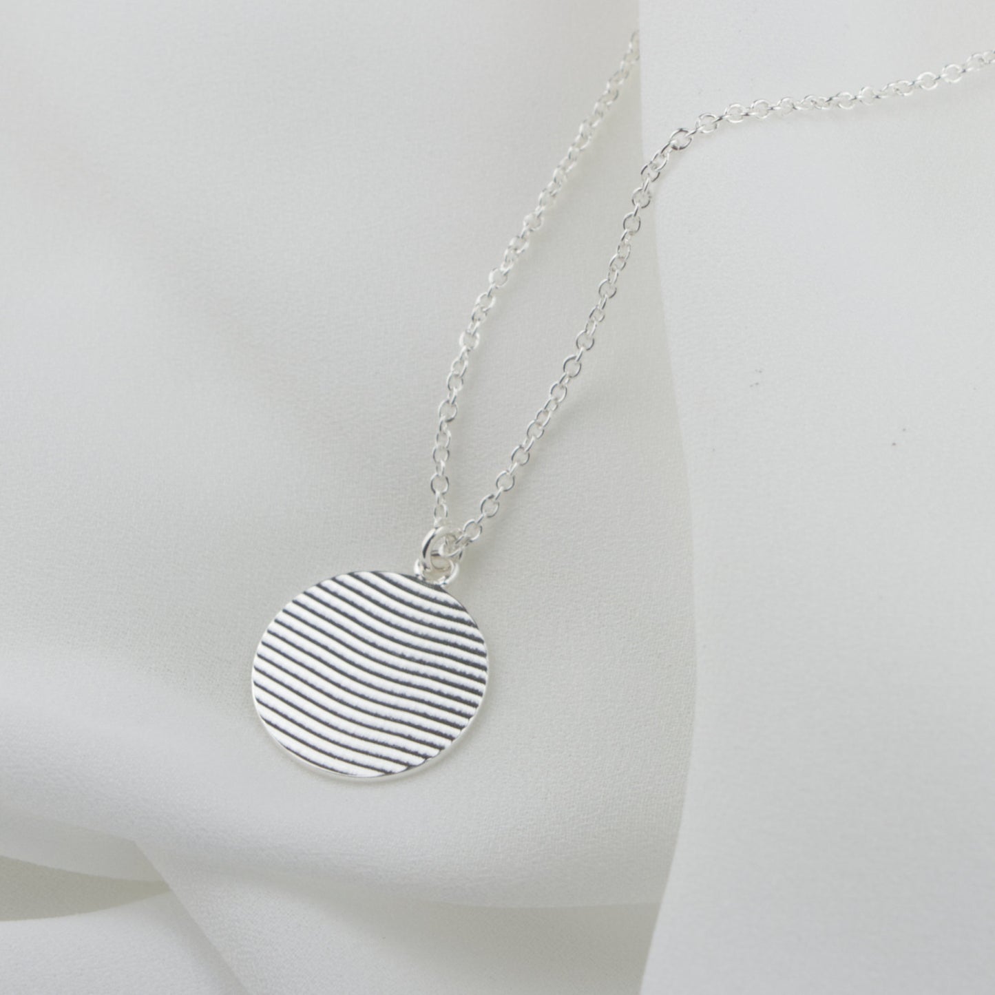 handmade silver circle necklace with ribbon texture