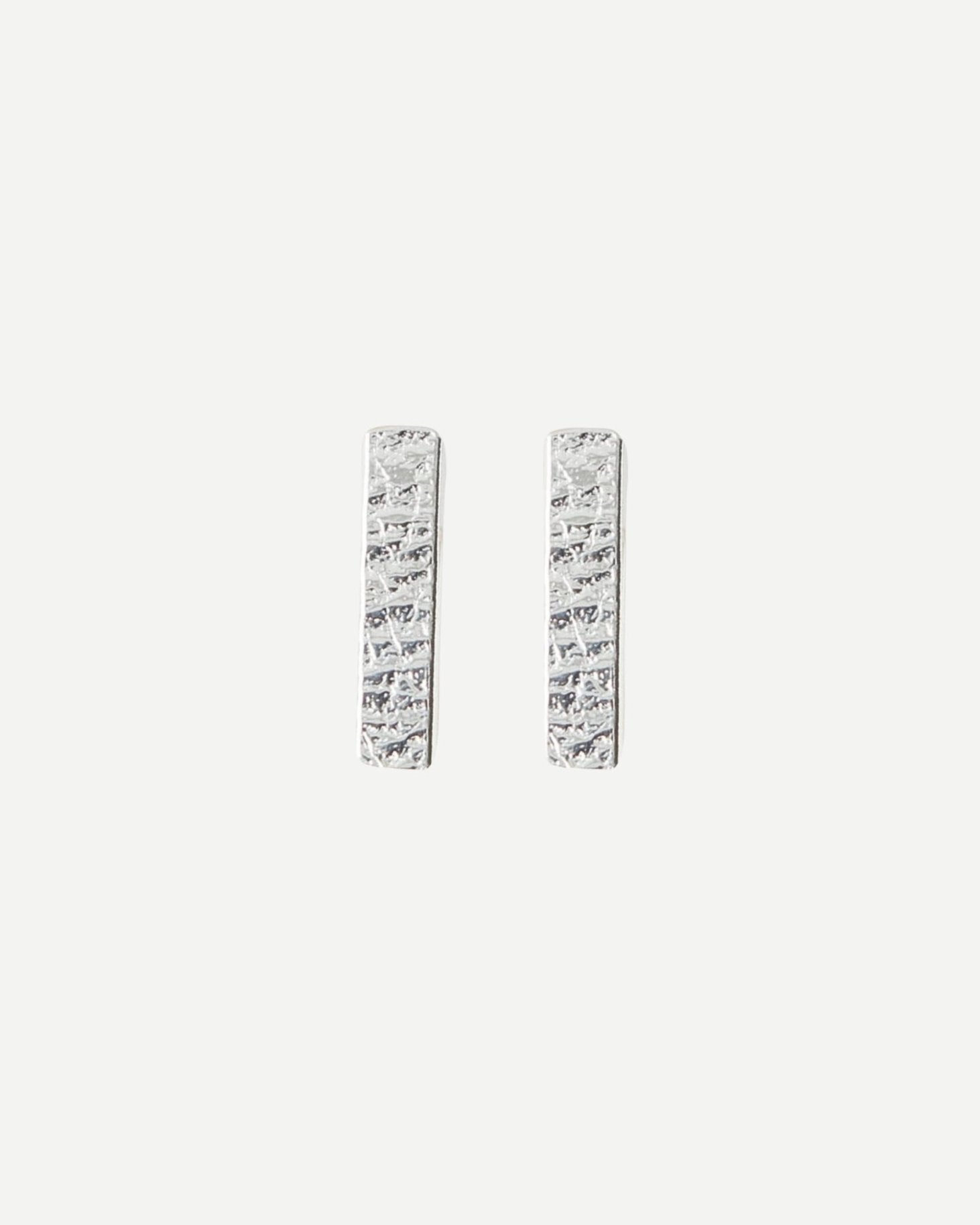 Silver rectangle bar stud earrings with delicate textured surface on white background