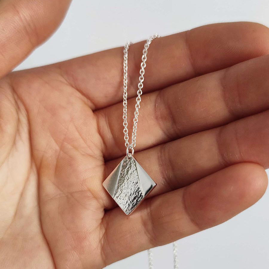 model holding simple everyday sterling square necklace