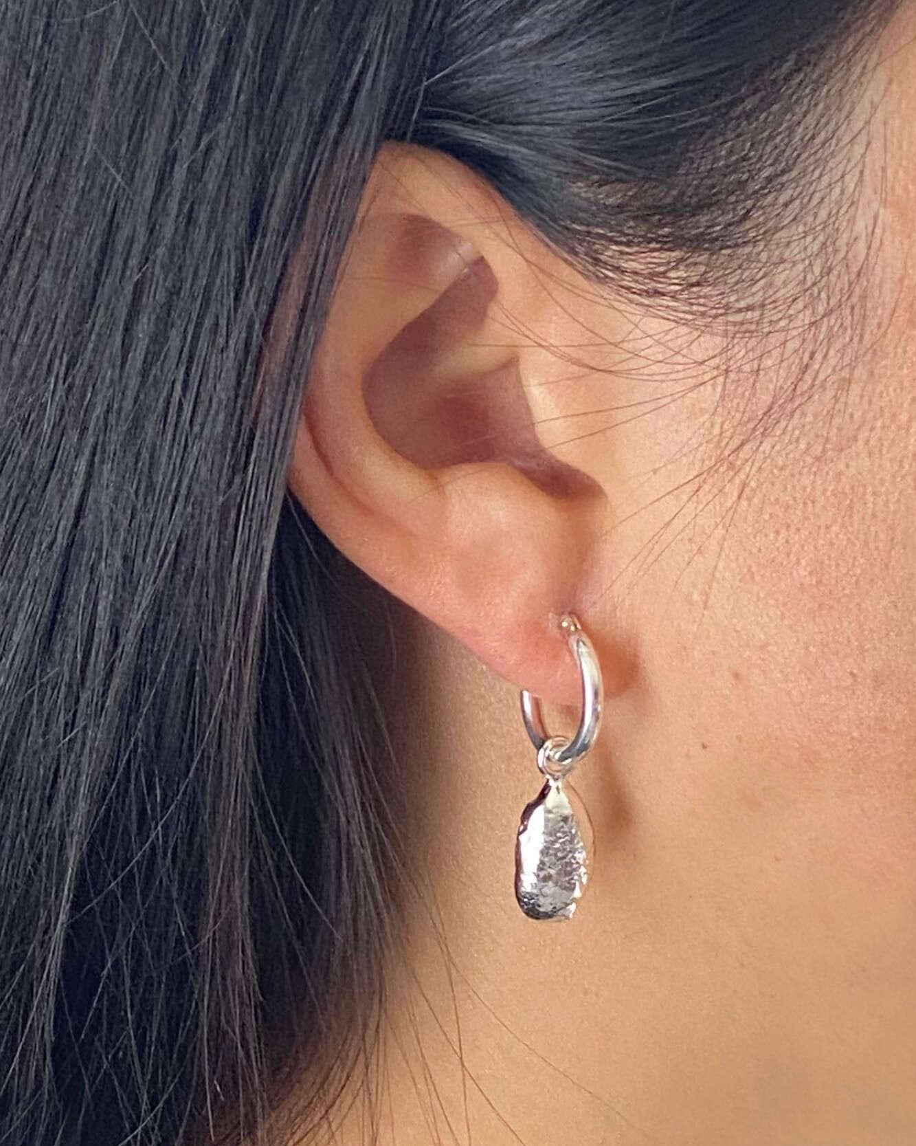 model wearing unique textured molten silver droplet earrings
