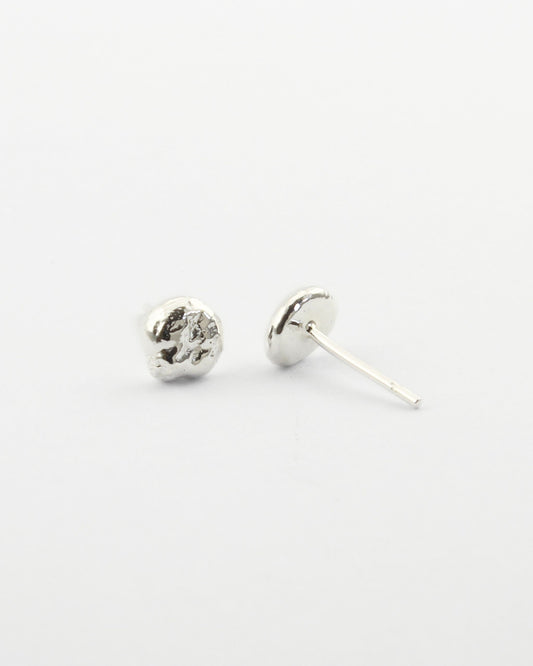 Small sterling silver circle-shaped stud earrings with off-white background