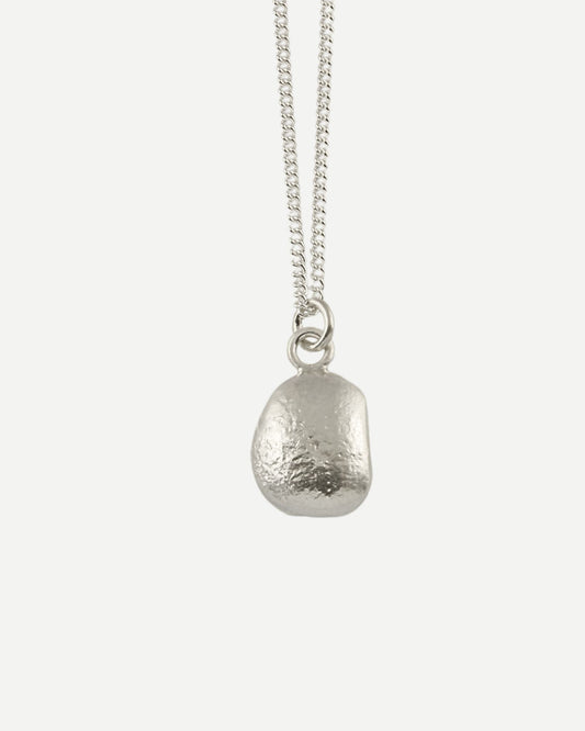 Front view of small molten silver pebble-shaped pendant hanging from fine silver curb chain with white background