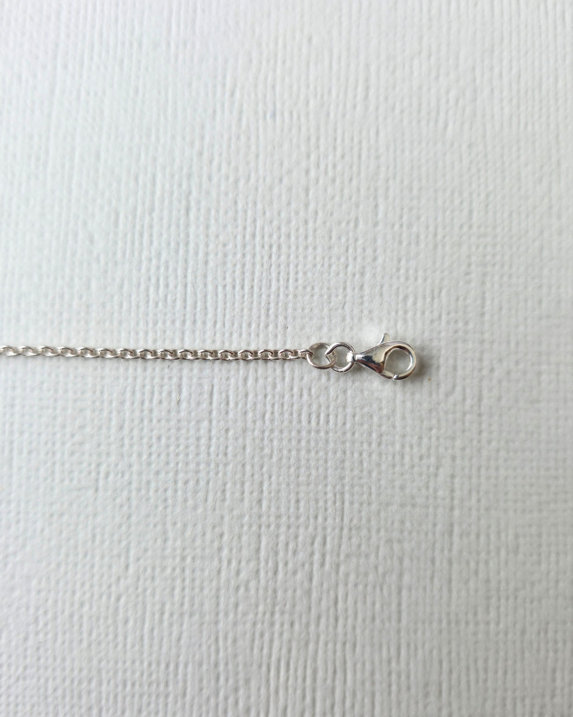 Close up of silver clasp on silver necklace chain