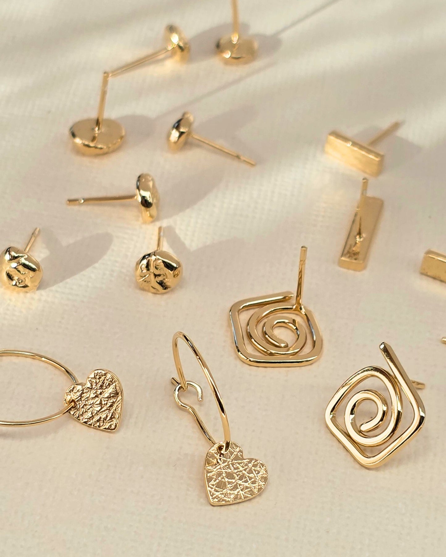 collection of delicate handcrafted gold studs on paper background