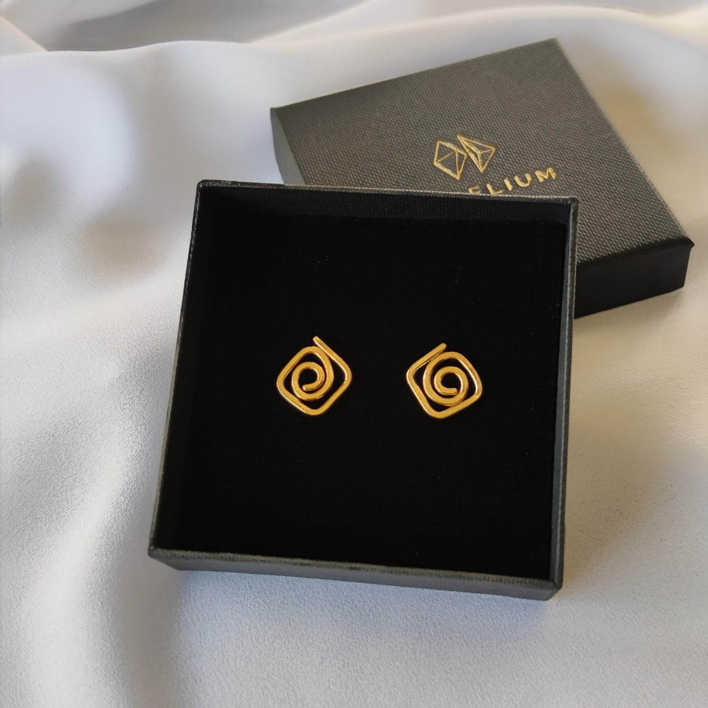 delicate gold diamond swirl stud earrings in gift box