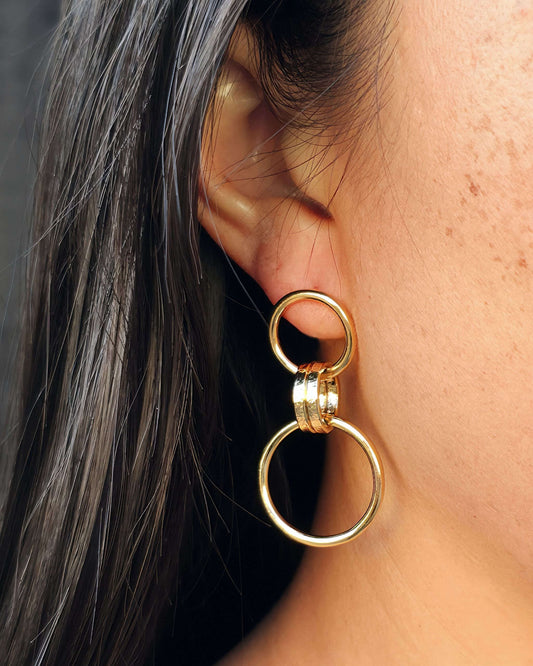 Close up of a person wearing an elegant gold link loop earring