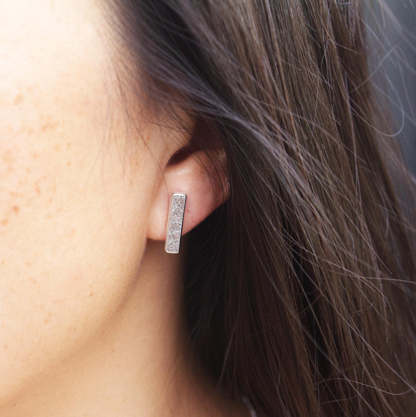 model wearing textured bar stud earrings