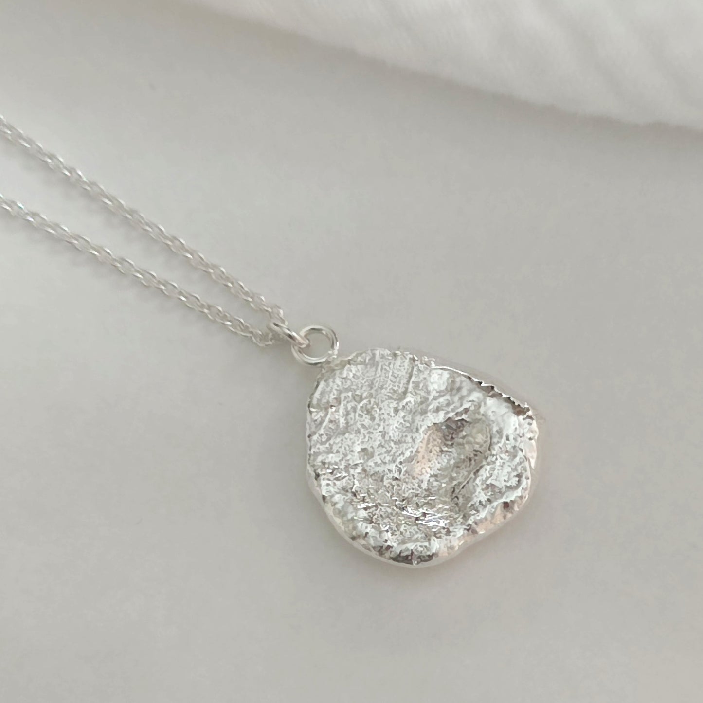 elegant polished sterling silver pendant with textured surface