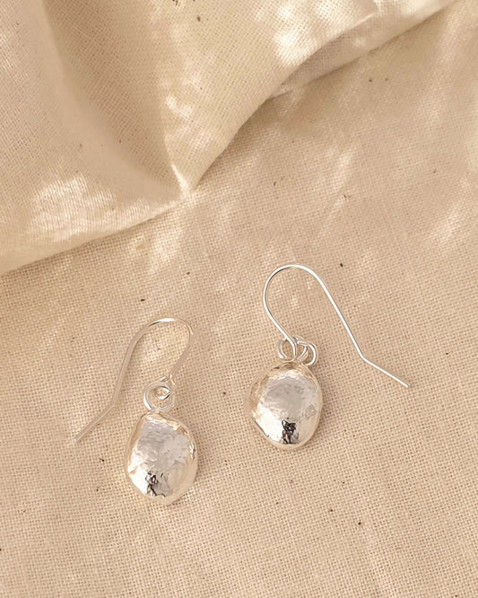 molten sterling silver teardrop earrings on a textured surface