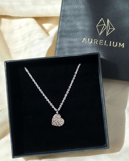 Silver heart-shaped pendant necklace in a black box with 'Aurelium' branding