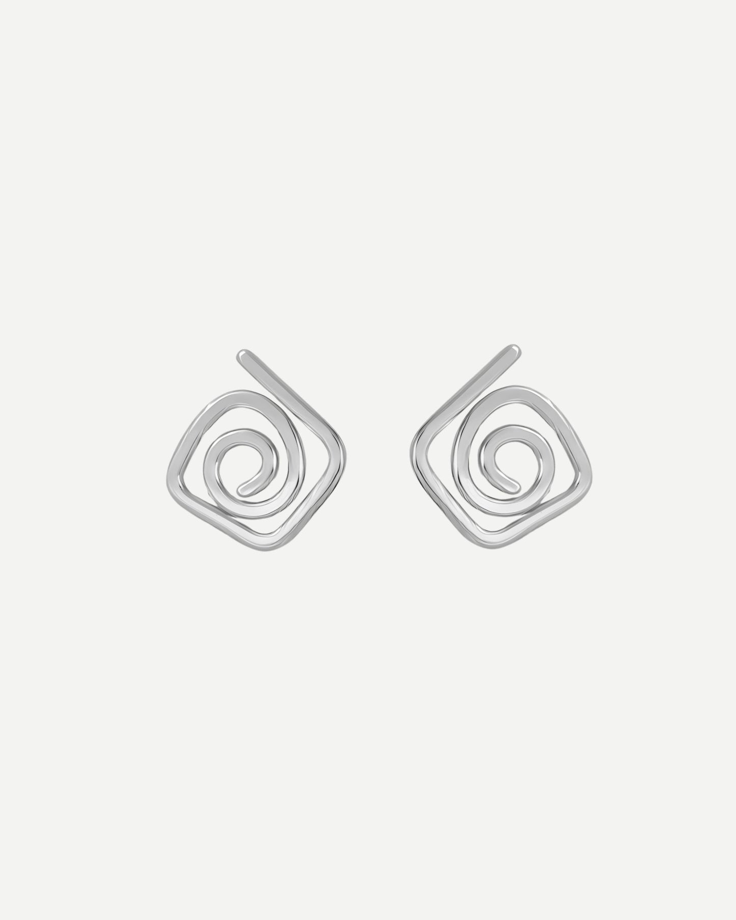 Pair of silver diamond shaped spiral stud earrings on a light grey background