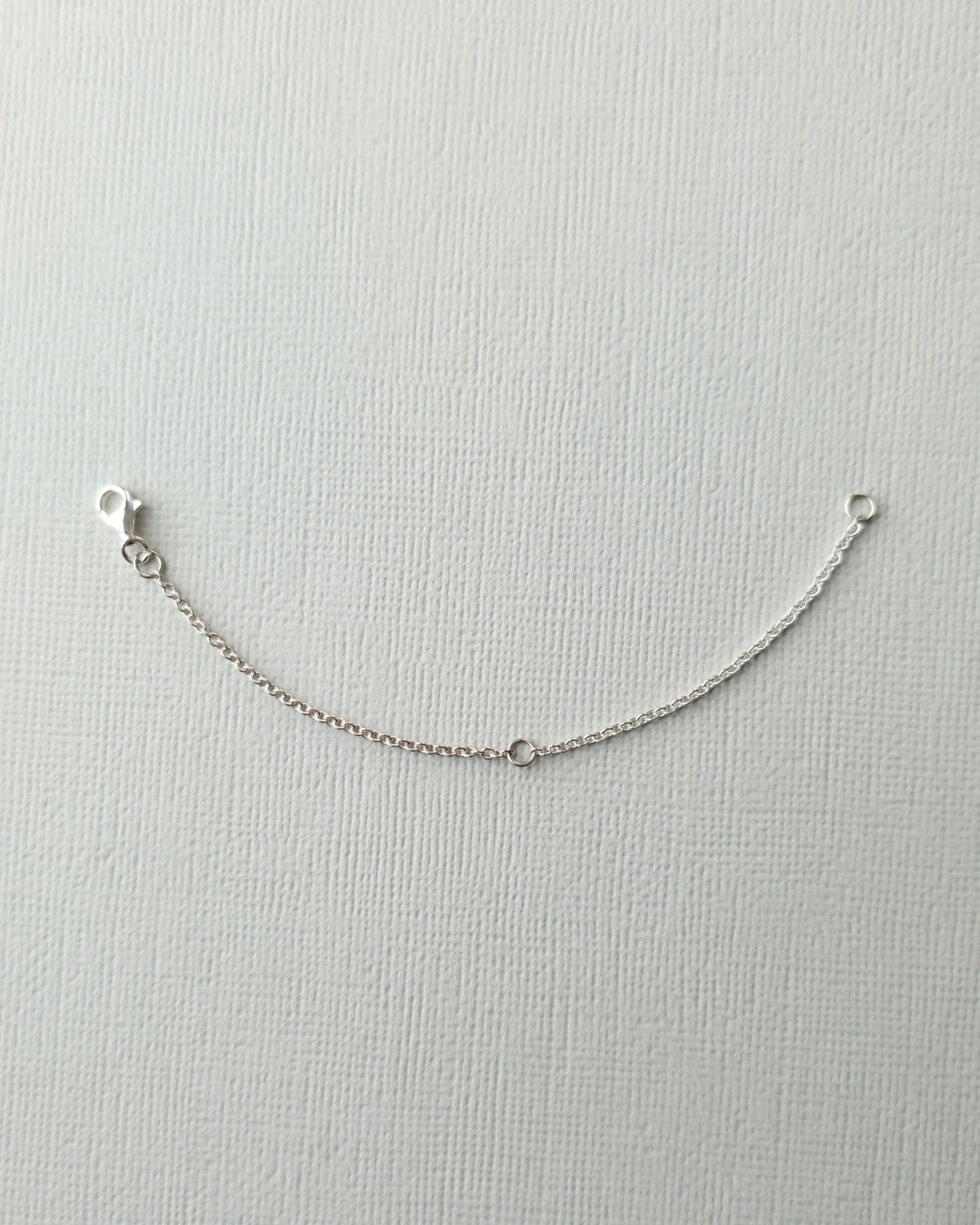 Sterling silver 10cm chain extender on textured paper background