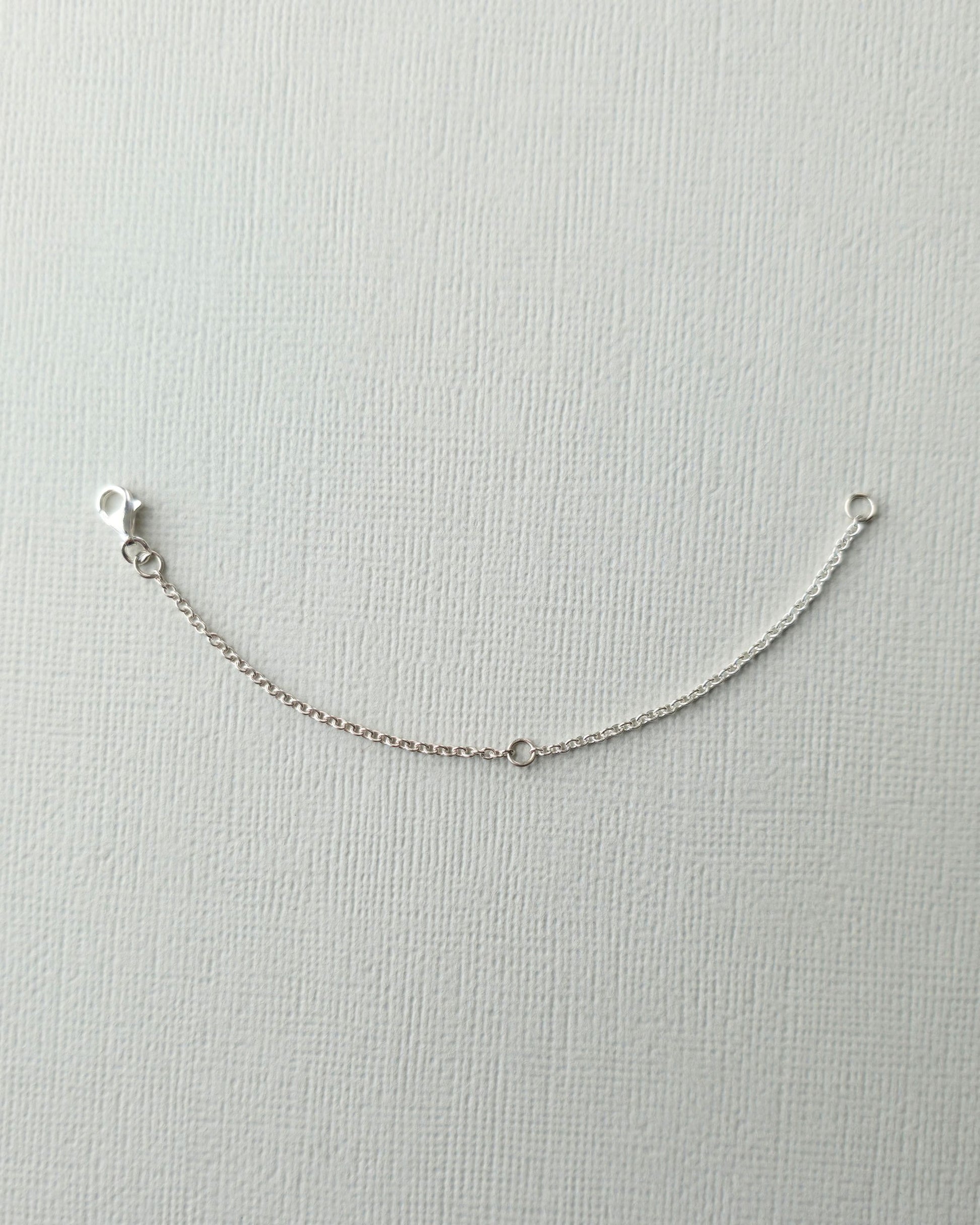 Sterling silver 10cm chain extender on textured paper background