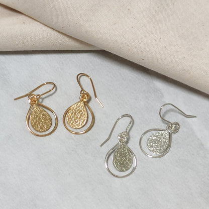 sterling silver and gold dewdrop earrings by aurelium on cream surface