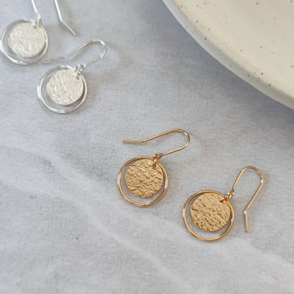gold and silver roundabout drop earrings by aurelium on marble background