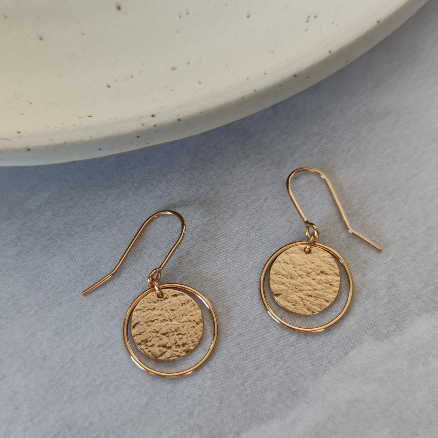 gold roundabout earrings by aurelium on marble background
