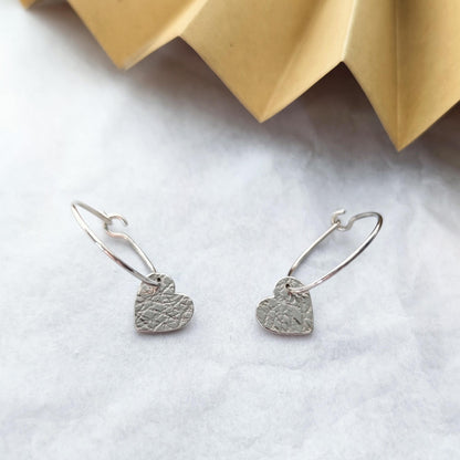 sterling silver sweetheart earrings on marble background